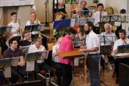 Kreisposaunenwart Martin Leue überreicht Angie Hunter ein Geschenk während der Geistlichen Abendmusik in der Karlshorster "Kirche zur Frohen Botschaft" mit Bläserinnen und Bläsern aus den Kirchenkreisen Lichtenberg-Oberspree und Nord-Ost. Foto: Jürgen Bosenius / KKLIOS