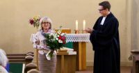 Christiane Vogel, Leiterin des ev. Dorfkindergartens Marzahn, freut sich über den Applaus der Gemeinde und Pfarrer Spiegelbergs anlässlich ihres 30-jährigen Dienstjubiläums. Foto: kklios
