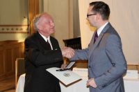 Der Bezirksbürgermeister von Treptow-Köpenik, Oliver Igel, verleiht Dr. Klaus Wazlawik (li.) das Bundesverdienstkreuz. Foto: kklios