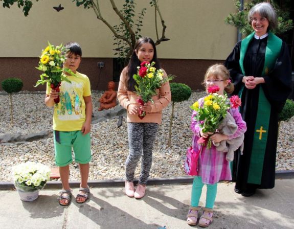 Ein Dankeschön von Pfarrerin Katharina Dang an Sam, Ayumi und Veerle für Ihre Mitarbeit am Bibelgarten. Foto: kklios